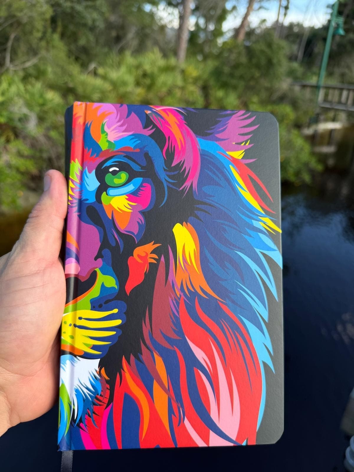 Biblia de tapa dura con ilustración de un león multicolor